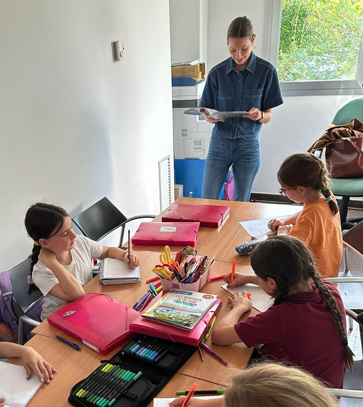 Une enseignante anime un atelier autour d'une table